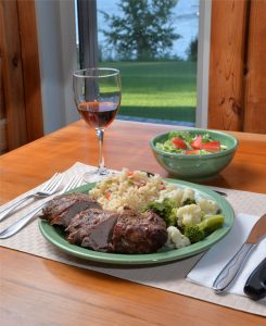 A plate of dinner, salad and wine at One Man Lake Lodge