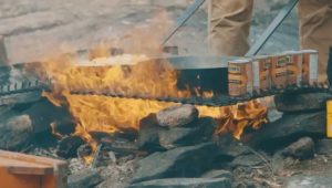 Pans of fish and cans of beans heating over the shore lunch fire