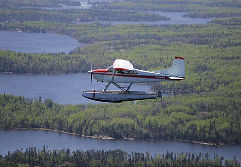 River Air float plane in flight over the English River.