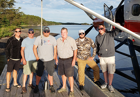 Group of six men about to board the float plane in Minaki.