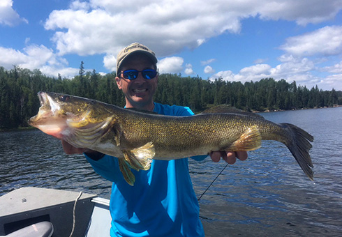 Happy man holding a 31 inch walleye.