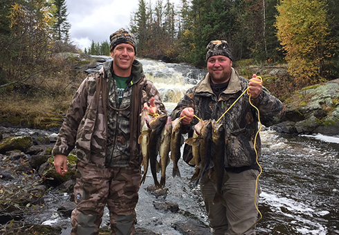 Two hunters with a stringer full of walleye.