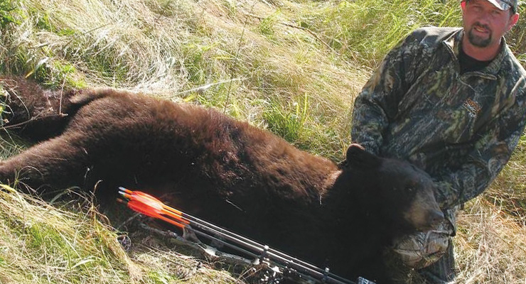 Downed black bear and the hunter.