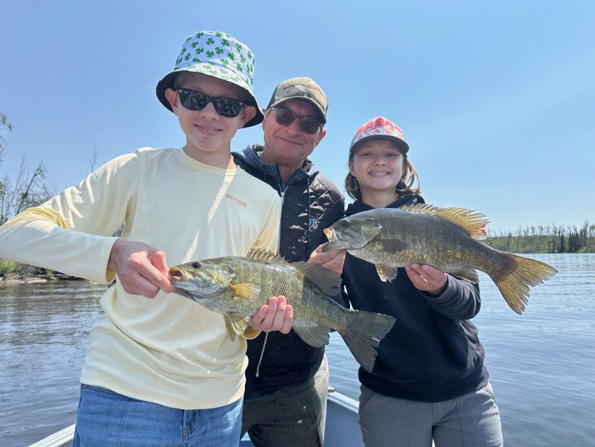 2 kids and their fishing guide both holding fish