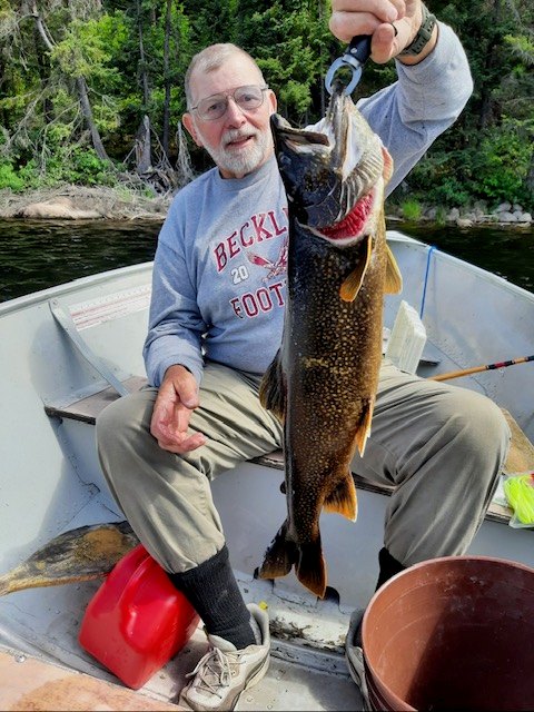 Man holding up a lake trout by the upper lip