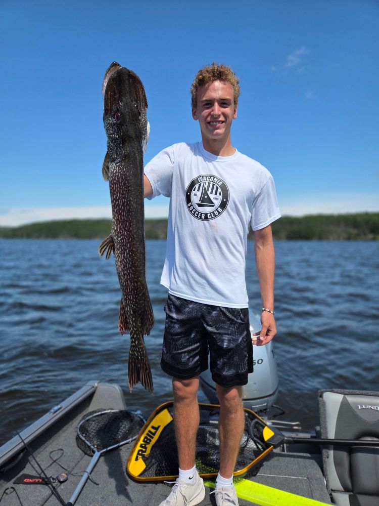 Young man holding another big pike