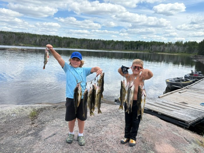 2 little kids proudly holding a stringer of fish!