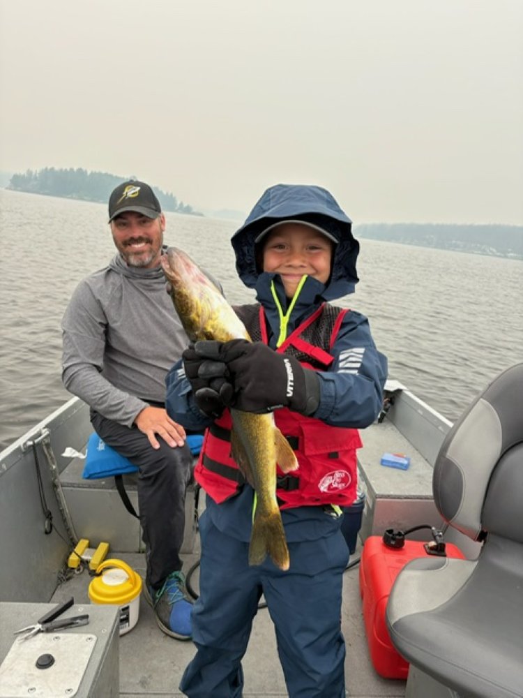 Little boy holding fish proudly