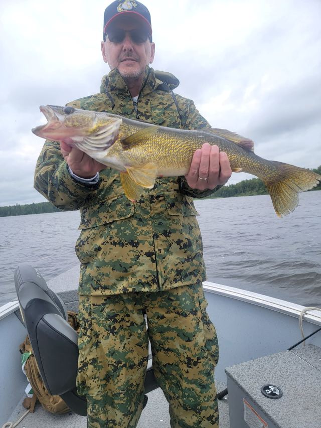 Man Holding a walleye in a boat