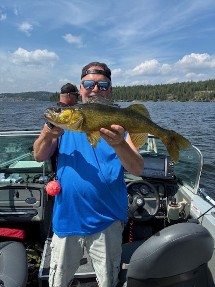 Man holding a fish with the sun showing a pretty golden color on the fish face