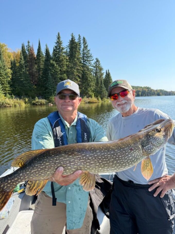 1 fishing guest and his Canadian fishing guide in a boat on a sunny day in September at Kettle Falls Lodge.