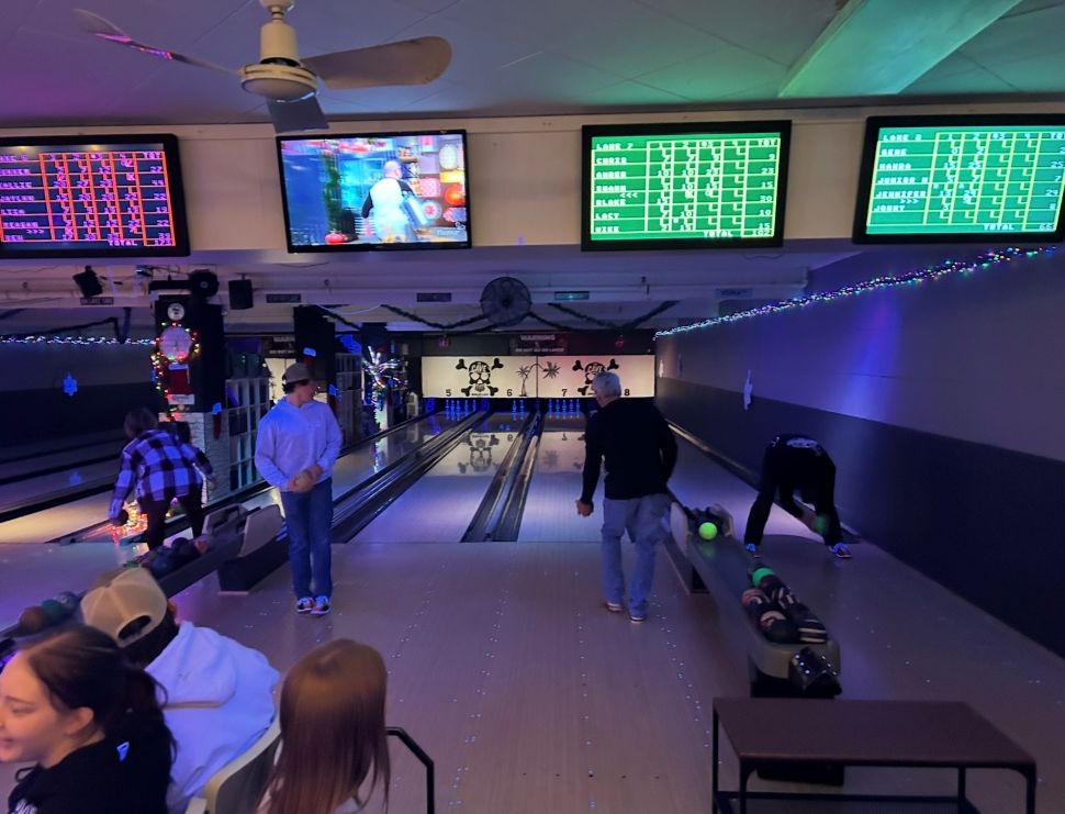 4 bowlers as part of staff Christmas party bowling down the lanes