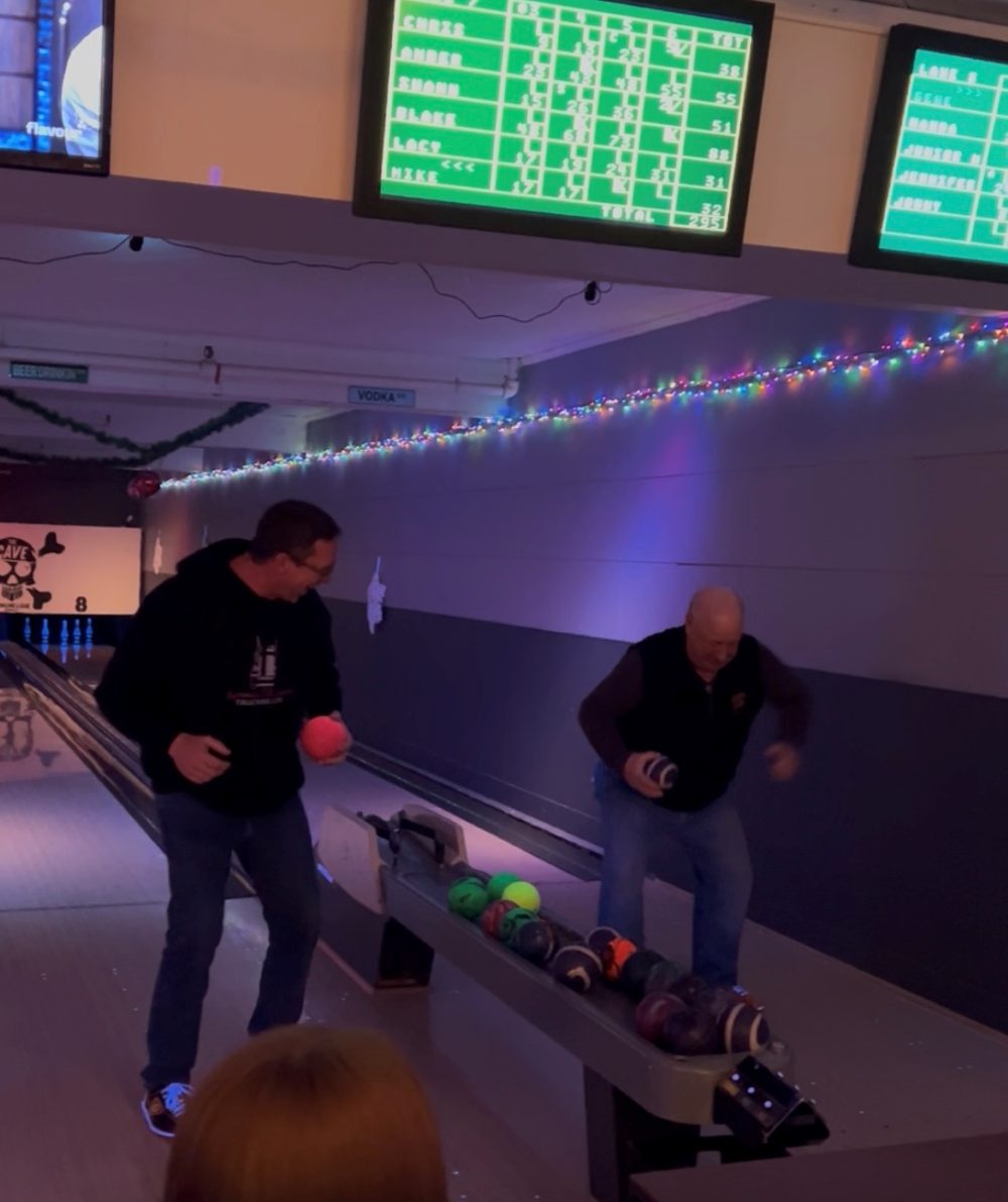 2 men playing a bowling game where they must dance before they have their turn at bowling